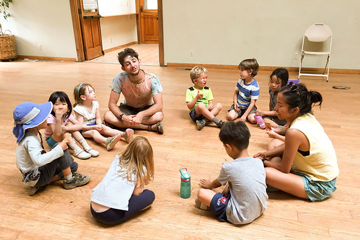 Two Leaders in Training sit in a circle with Kinder campers