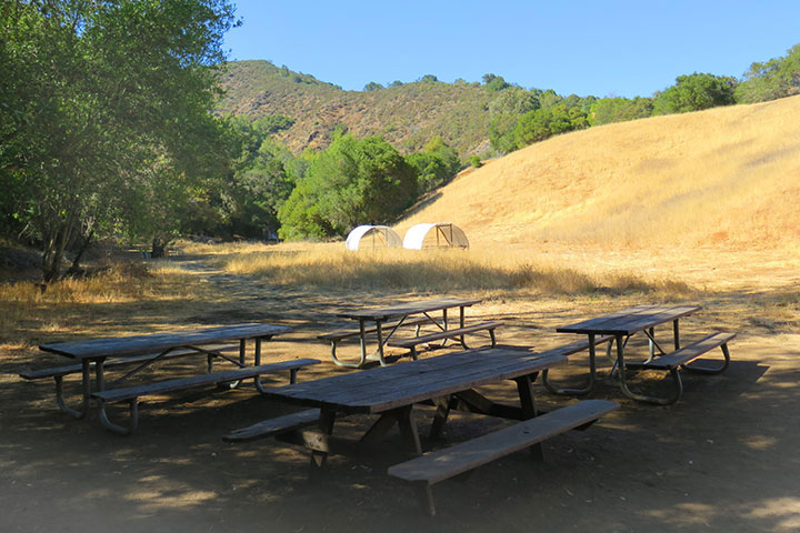 Picnic tables by a hill